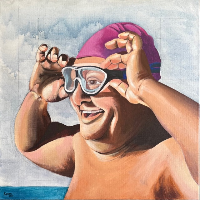 Man in pink swimming hat and goggles, at the beach